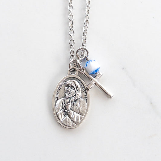 St Teresa of Calcutta necklace with silver Mother Teresa medal, small cross charm, and blue white bead on stainless steel chain