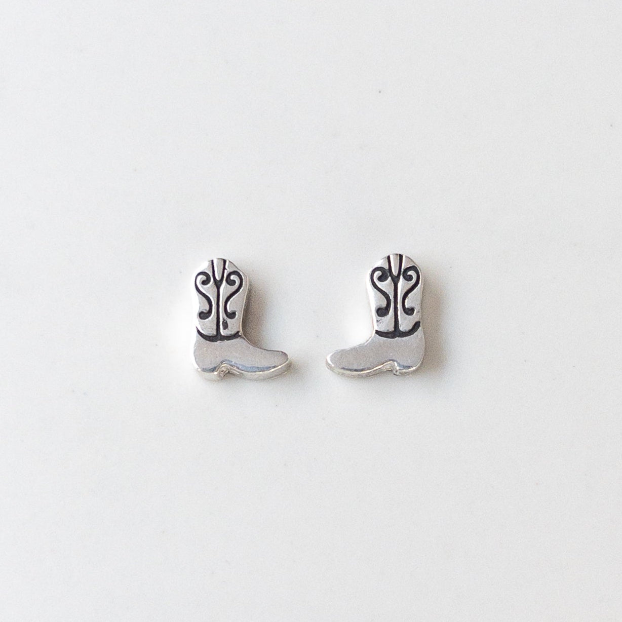 Sterling silver cowboy boot stud earrings in .960 silver, displayed on neutral background – Western rodeo-inspired Catholic jewelry by Sagely Sparrow