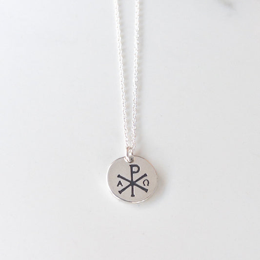 Sterling silver Chi Rho necklace with Alpha and Omega on an 18-inch silver-filled chain; minimalist Christian jewelry on a white background.