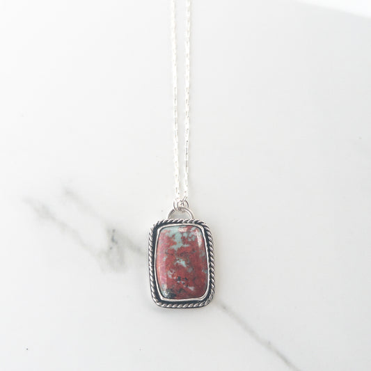 Sonoran Sunrise gemstone necklace in sterling silver with twisted wire bezel and crucifix cutout back, displayed on neutral fabric – Catholic statement jewelry