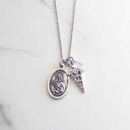 Catholic nurse necklace featuring St. Catherine of Siena medal, silver caduceus charm, and clear glass crystal accent bead.
