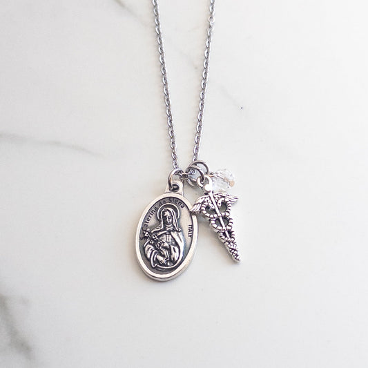 Catholic nurse necklace featuring St. Catherine of Siena medal, silver caduceus charm, and clear glass crystal accent bead.