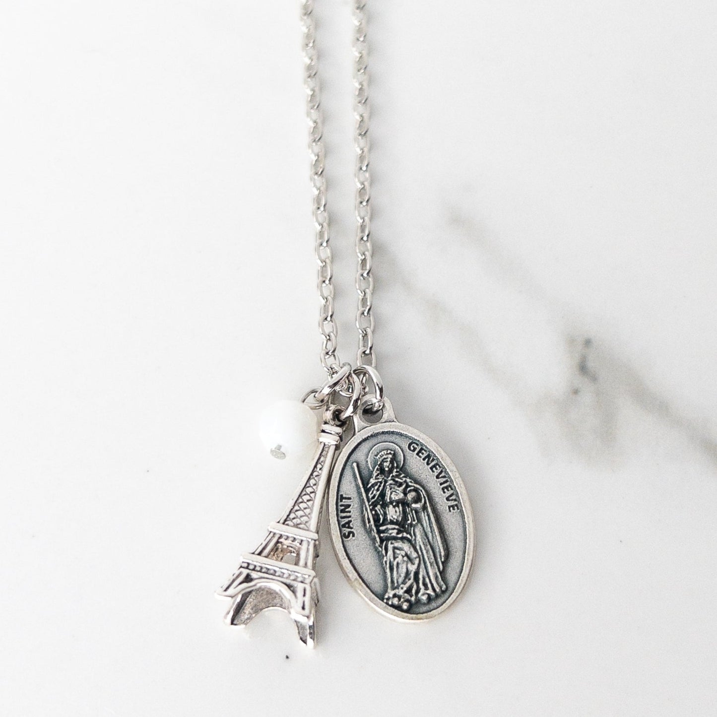St. Genevieve patron saint necklace with silver Saint Genevieve medal, 3D Eiffel Tower charm, and white bead on stainless steel chain, Catholic saint jewelry gift