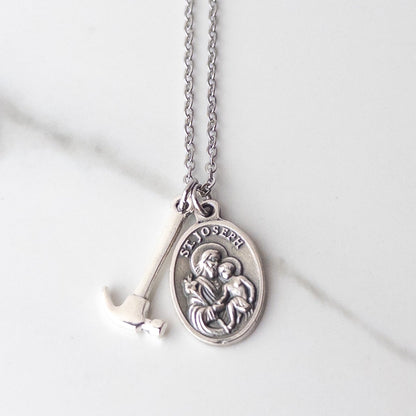 St Joseph the worker medal necklace with silver tone hammer charm on stainless chain. Catholic gifts for dads.
