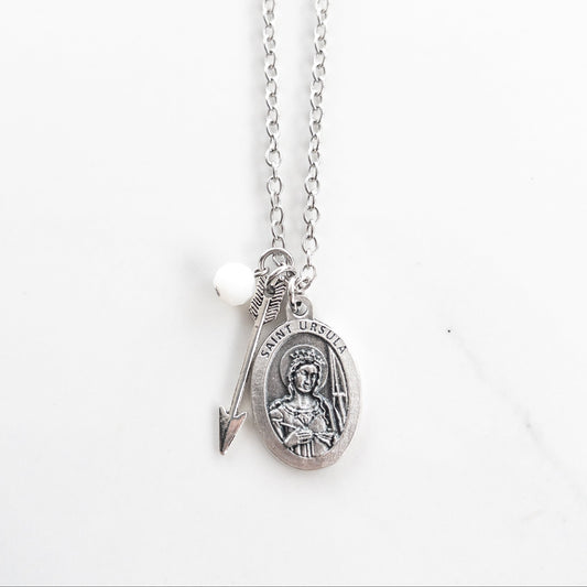 Saint Ursula medal necklace with silver arrow charm and white glass bead on a stainless steel chain