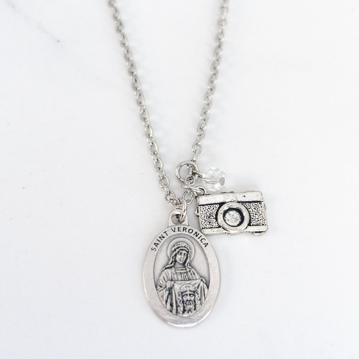 Saint Veronica necklace with silver medal and camera charm on stainless steel chain, Catholic patron saint of photographers jewelry
