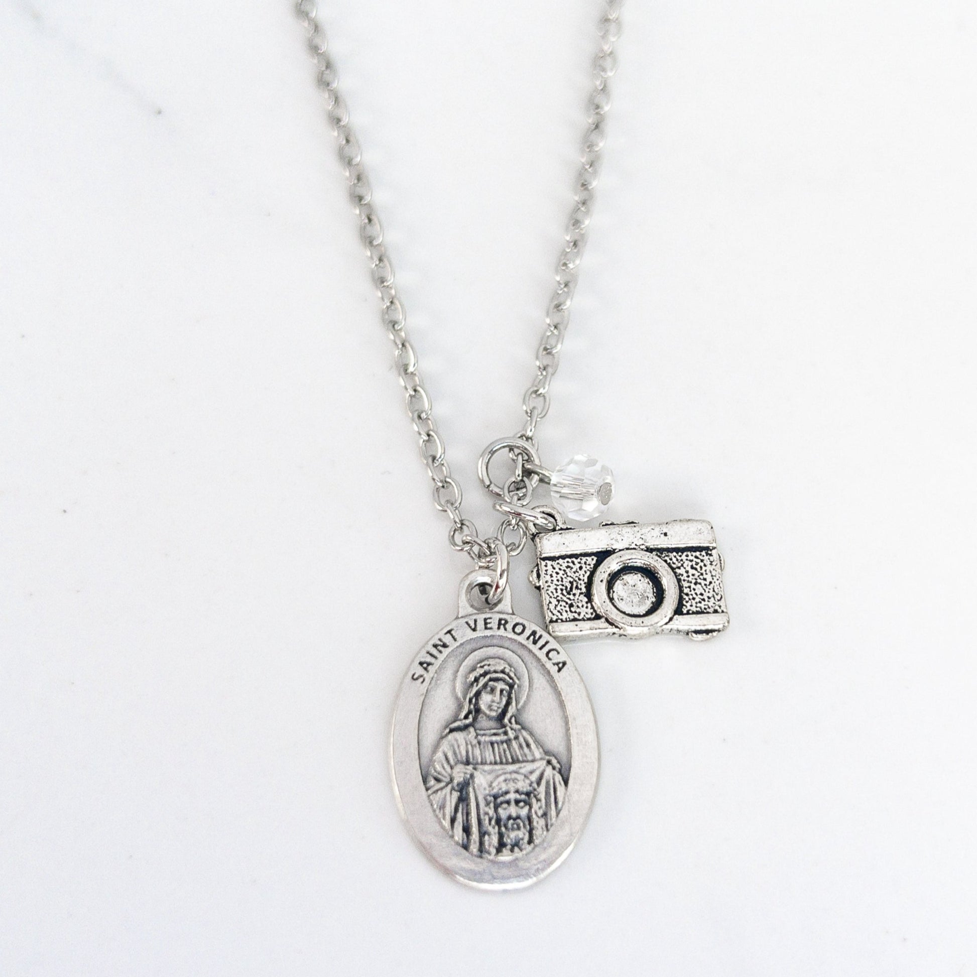 Saint Veronica necklace with silver medal and camera charm on stainless steel chain, Catholic patron saint of photographers jewelry