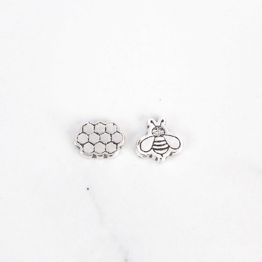 Sagely Sparrow Bee and Honeycomb Stud Earrings on a  white background. Honeycomb on left and bee on right.