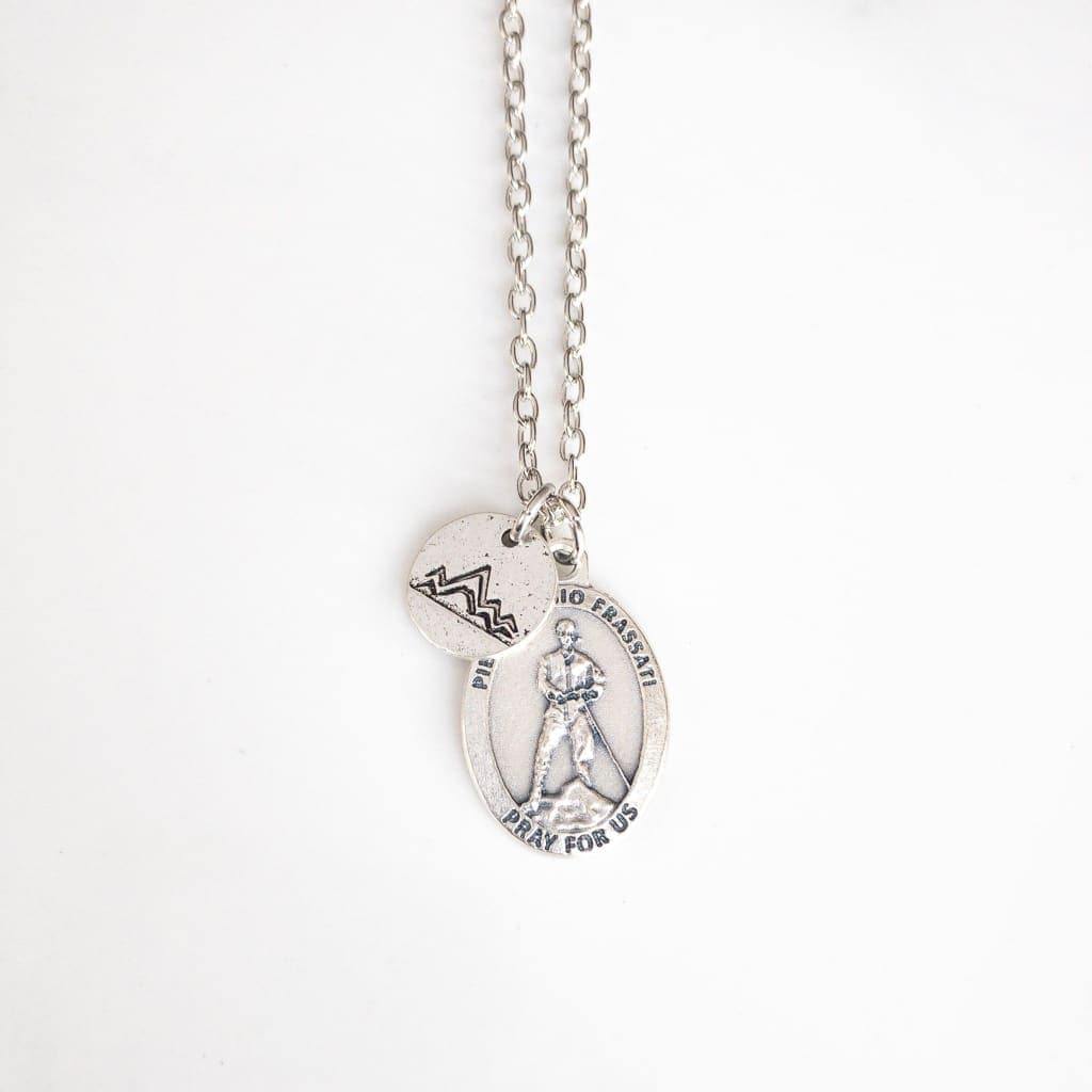 Blessed Pier Giorgio Frassati Necklace - Saint Necklace - Sagely Sparrow - Necklace is shown on a white background. Silver colored chain with small silver colored mountain charm over silver colored Blessed Pier Giorgio Frassati saint medal